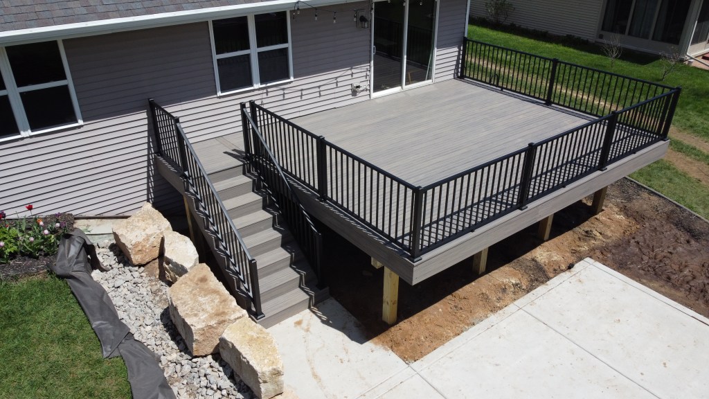 Elevated Trex Enhanced Naturals Rocky Harbor composite deck attached to a gray house